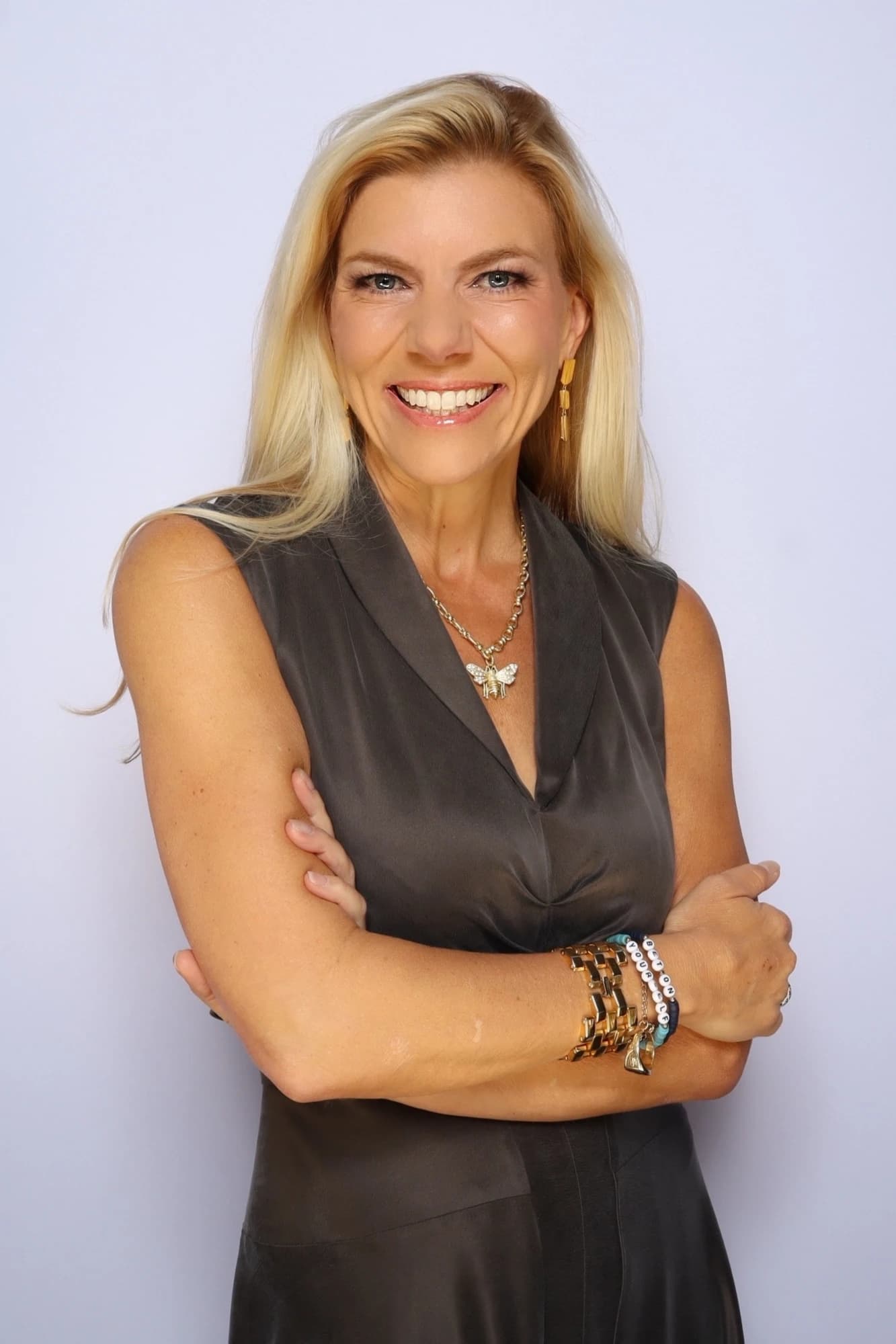 Molly Grantham, arms crossed, smiling in a studio portrait